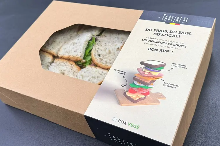 Box lunch Tartineke en carton kraft à fenêtre, garnie de sandwiches sur pain aux graines, pour business lunch livré à Louvain-la-Neuve