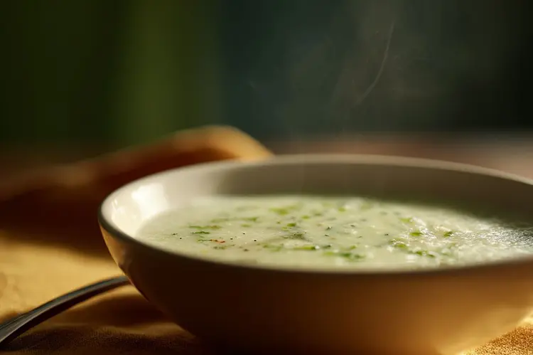 Bol de soupe fumante aux poireaux dans une ambiance feutrée, pour livraison lunch d'entreprise à Wavre